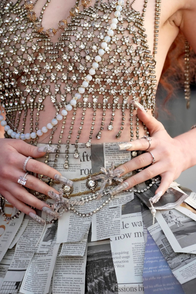 Chappell Roan wears a skirt made of newspaper print and her nails mimic the same pattern dotted with pearls.